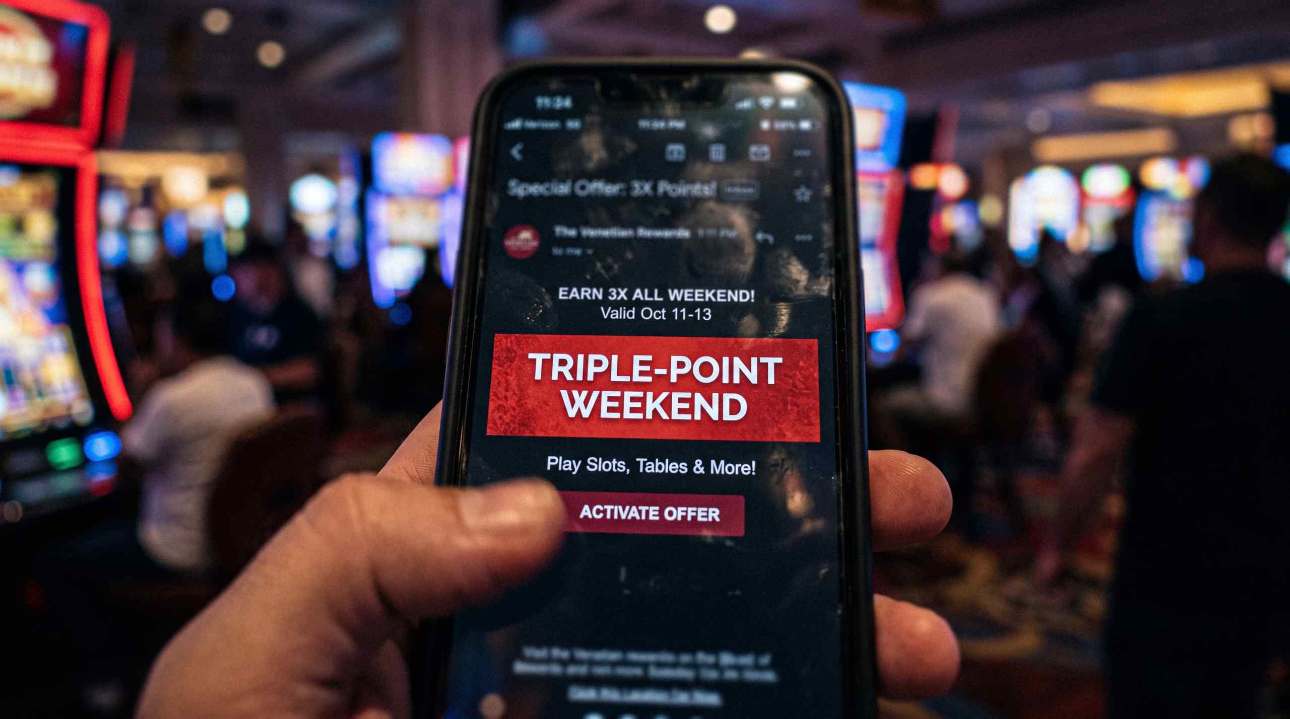 A promo displayed on a mobile phone while a man navigates a casino.